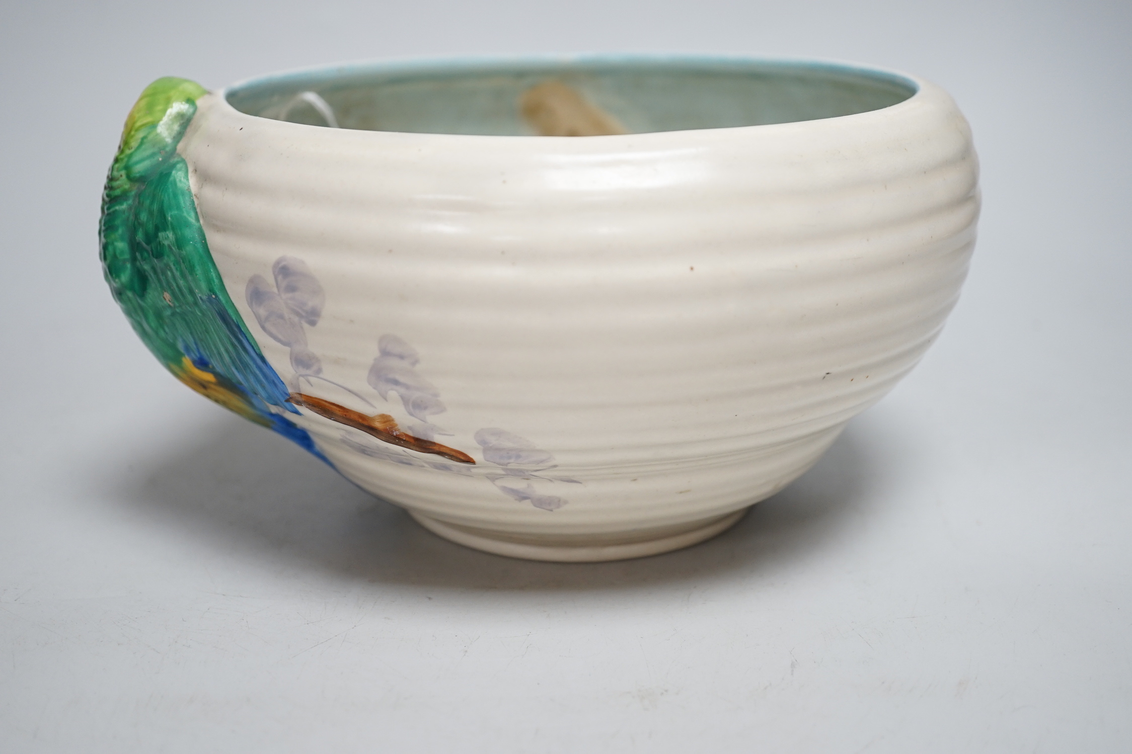 A late Clarice Cliff bowl with perched parrot decoration, 12cm tall